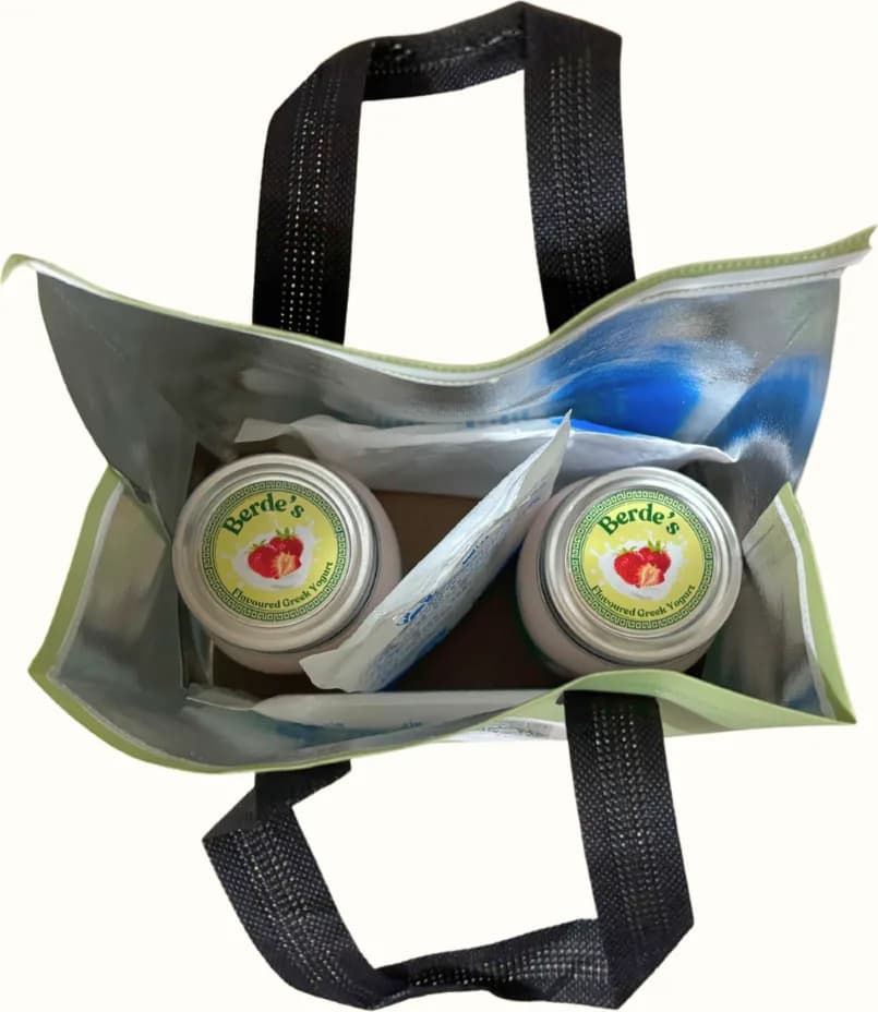 An opened thermal bag seen from above: two jars of Berde's yogurt beside an ice pack, inside a foil lining.